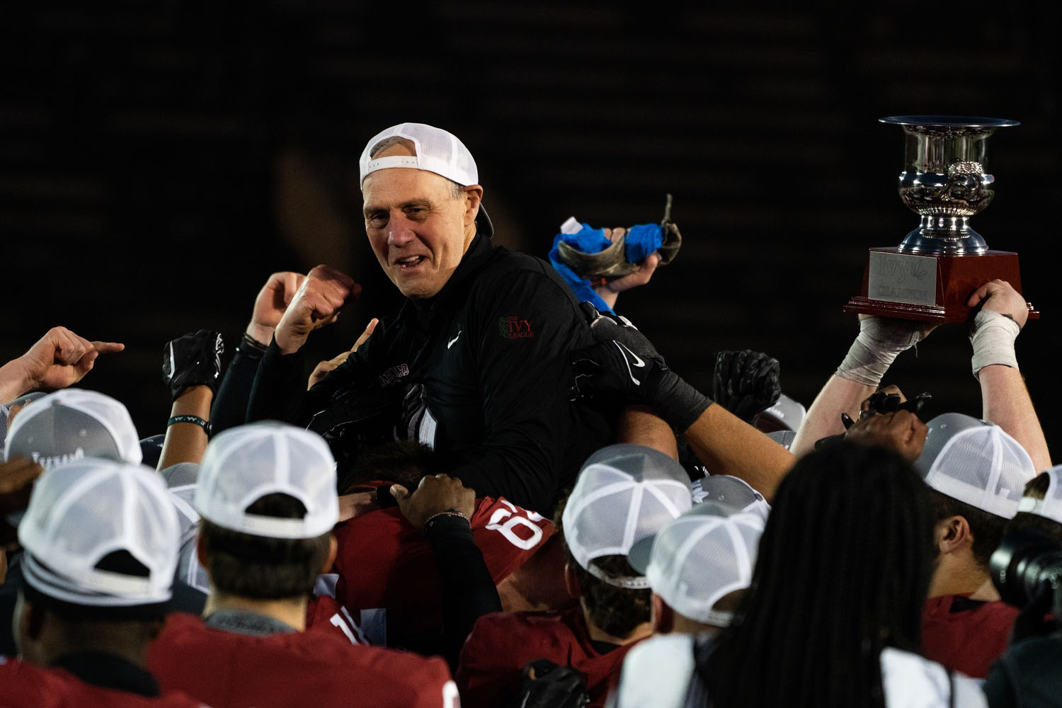 Harvard football head coach Tim Murphy celebrates with his players after his team's victory over Penn, which secured a share of the Ivy League title for the Crimson.