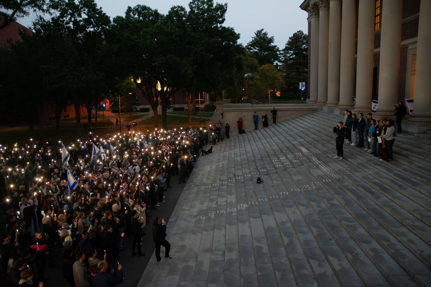 More than 1,000 people gathered by the steps of Widener Library Sunday evening for a vigil to stand in solidarity with Israel and mourn the civilian deaths of the Oct. 7 invasion by Islamist militant group Hamas. Candles on the steps spelled out חי, the Hebrew word for life.