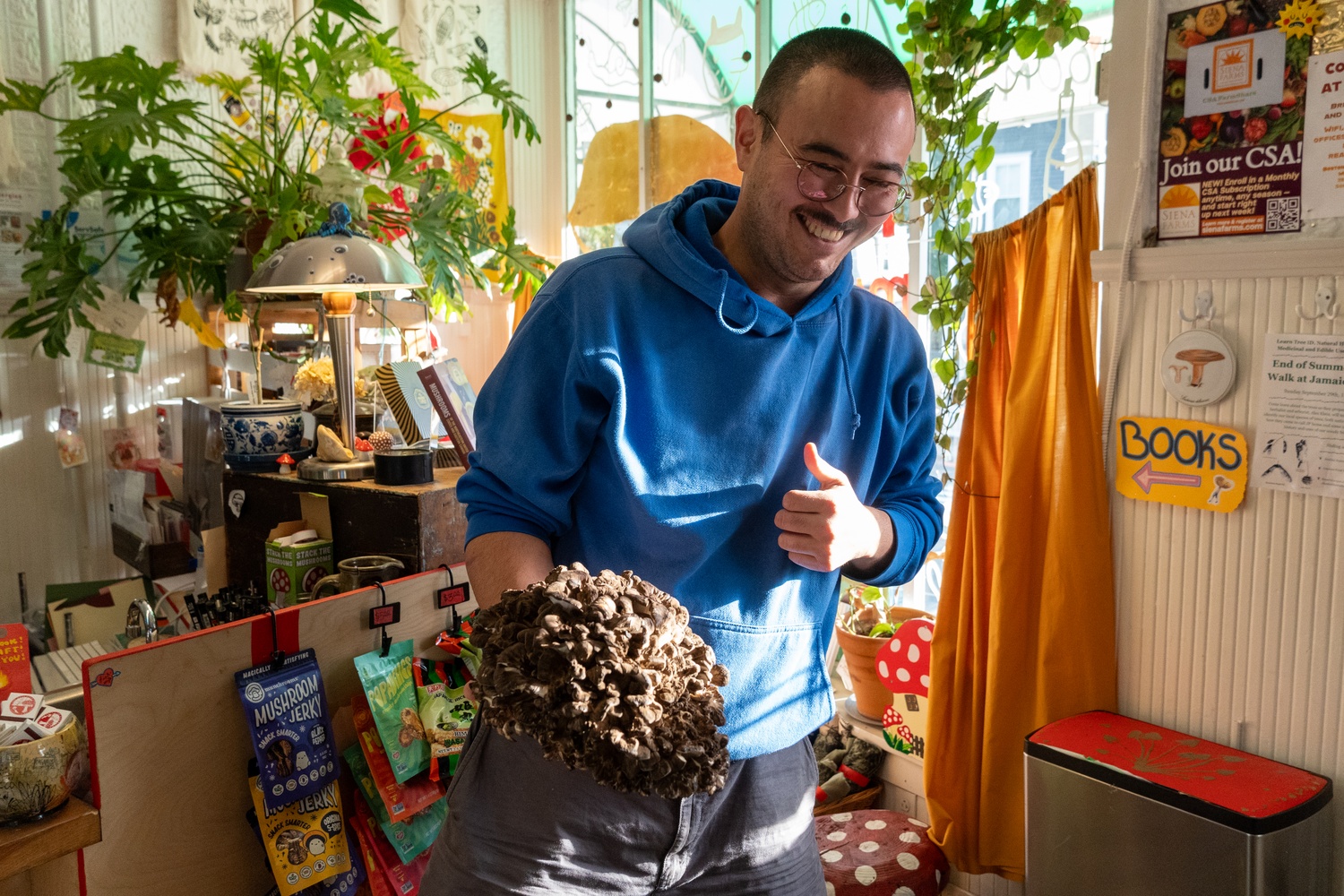 Tyler Akabane, founder of The Mushroom Shop in Somerville, displays a freshly foraged Hen-of-the-Wood mushroom. The shop sources rare and seasonal fungi for local restaurants and home cooks, offering both fresh ingredients and mushroom-themed merchandise.