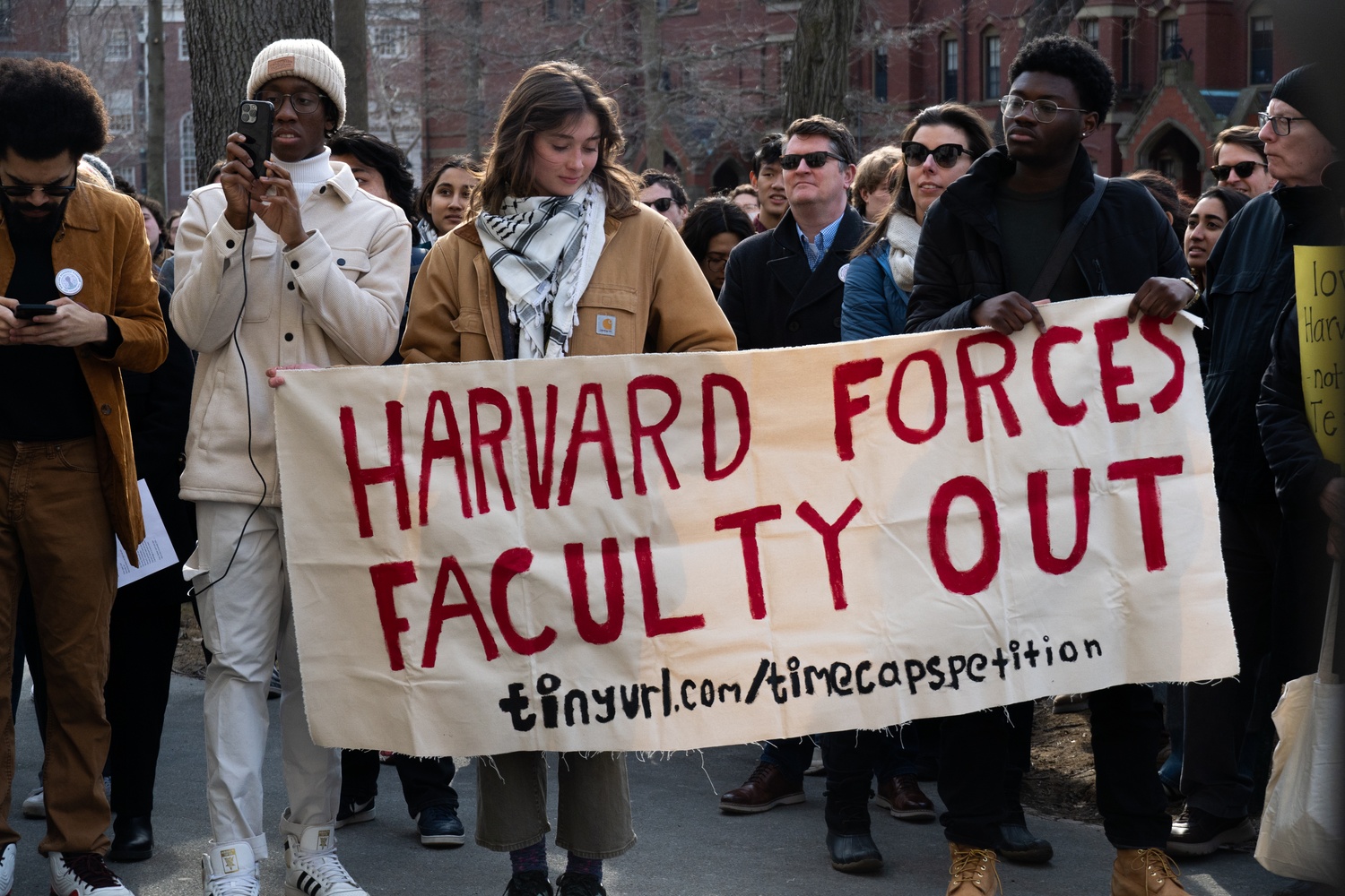 Students carry a banner through Harvard Yard during a walkout protesting time caps on non-tenure-track faculty. The demonstration, organized by the Harvard Academic Workers Union and the Student Labor Action Movement, called on the University to end limits on lecturer and preceptor appointments.