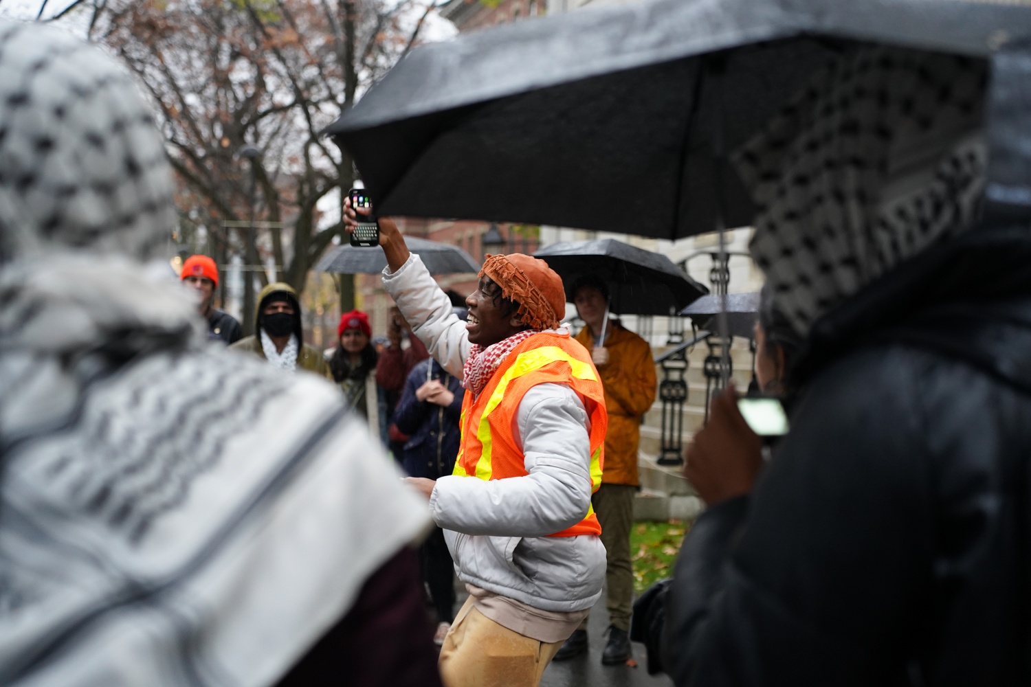 Harvard undergraduate Kojo Acheampong ’26 jumps in chant as he’s surrounded by fellow protesters during a walkout held by Harvard Out of Occupied Palestine in Harvard Yard. More than 40 students rallied to demand divestment from companies tied to human rights abuses.