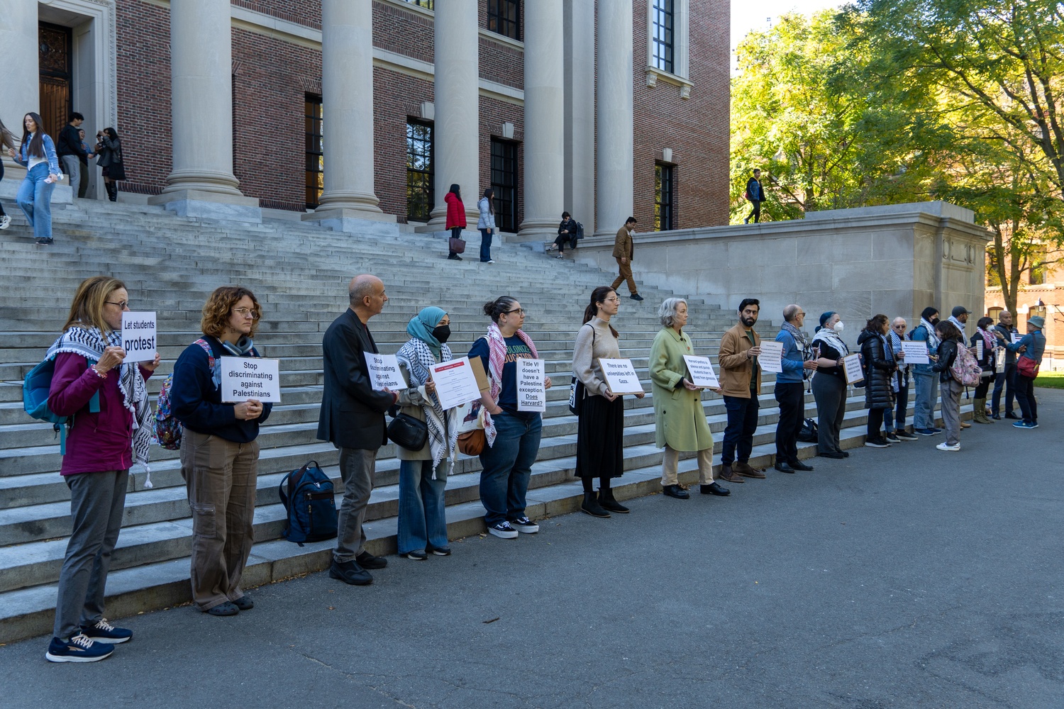 After pro-Palestine students were temporarily banned from Widener Library following a study-in protest, more than a dozen Harvard faculty members gather in front of the library to protest. The action, organized by Faculty and Staff for Justice in Palestine, called the ban a threat to free expression.