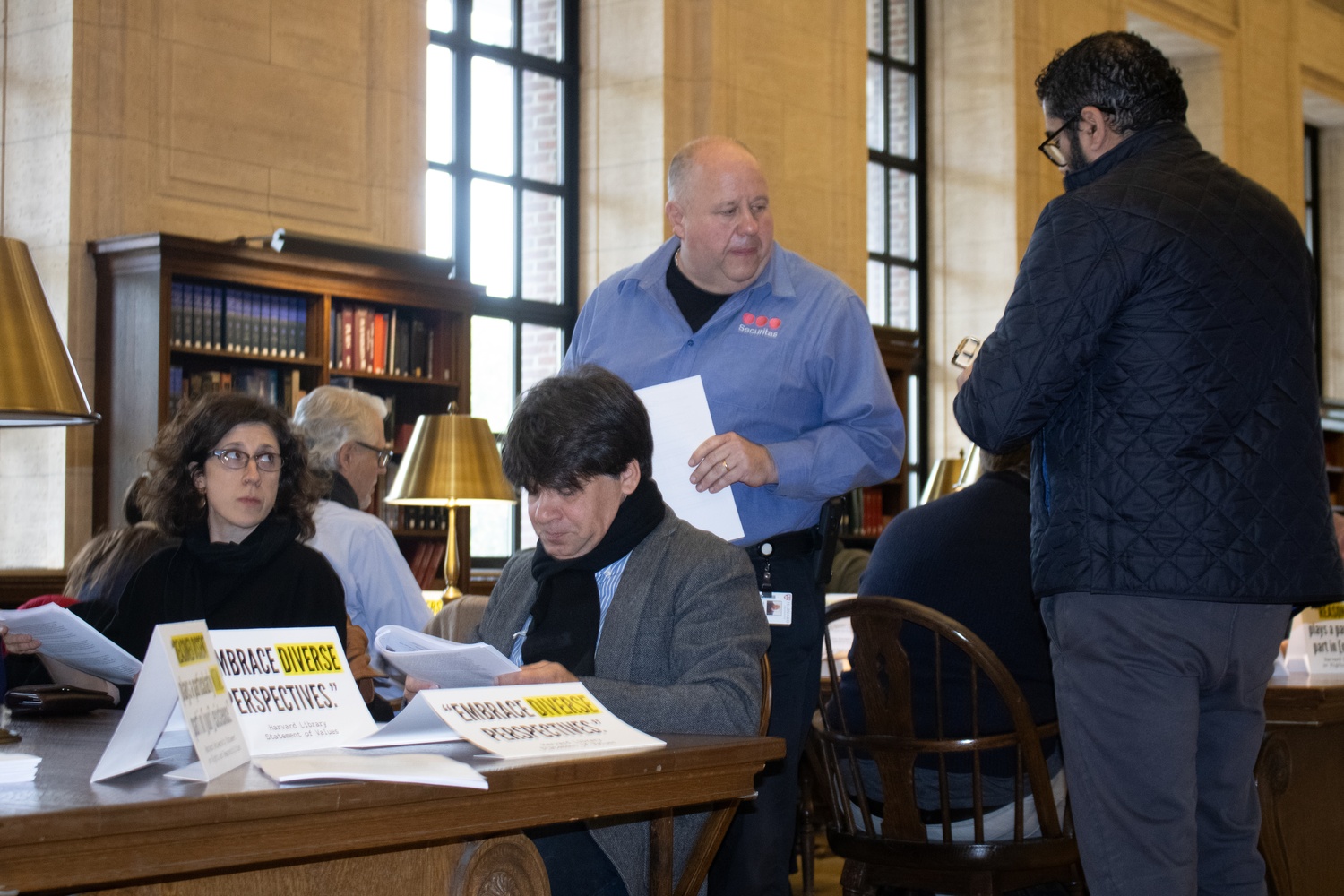 A Securitas guard notes the Harvard University ID numbers of faculty members who participated in a study-in at Widener Library to protest the University's temporary suspension of student activists from the building.
