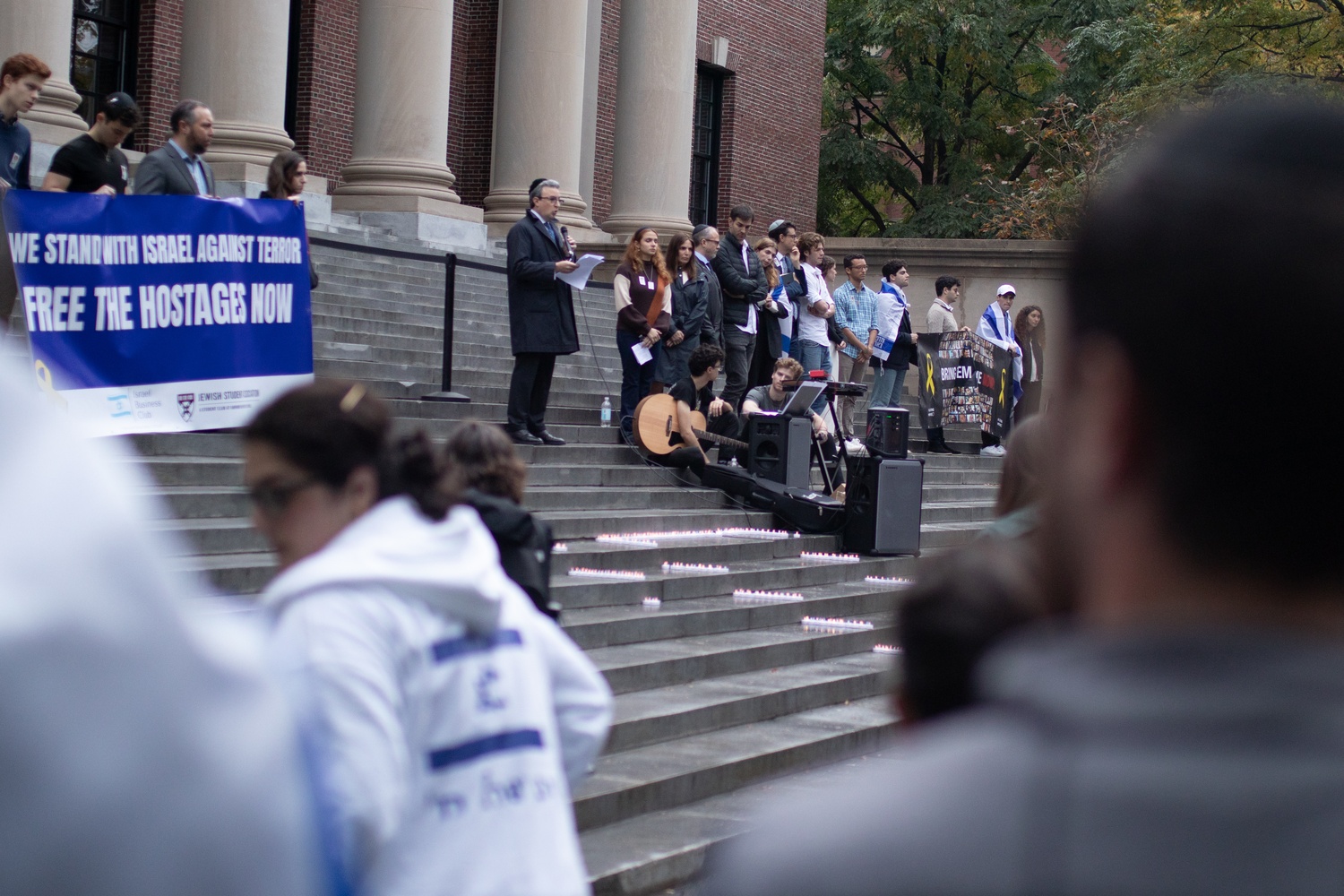 An attendee speaks on the steps of Widener Library during a vigil marking the anniversary of Hamas’ Oct. 7 attacks on Israel. The event, organized by Harvard Hillel and Chabad, included speeches, musical performances, and a reading of victims’ names.