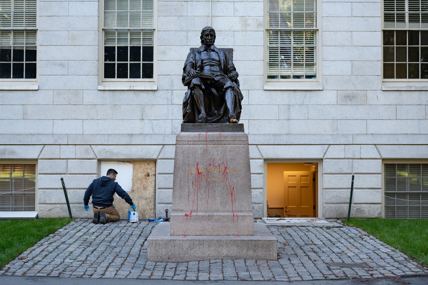 An individual splashed the John Harvard statue with red paint and smashed windows at University Hall in an act claimed online as “solidarity with the Palestinian resistance.” Harvard officials boarded up the damage and police launched an investigation.